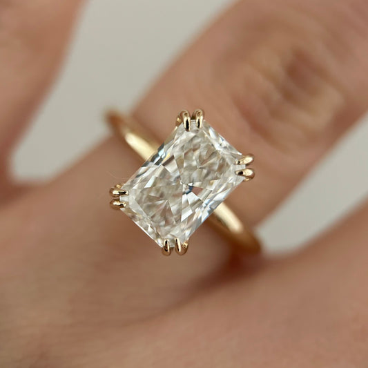 14K Double prong radiant cut diamond solitaire ring.