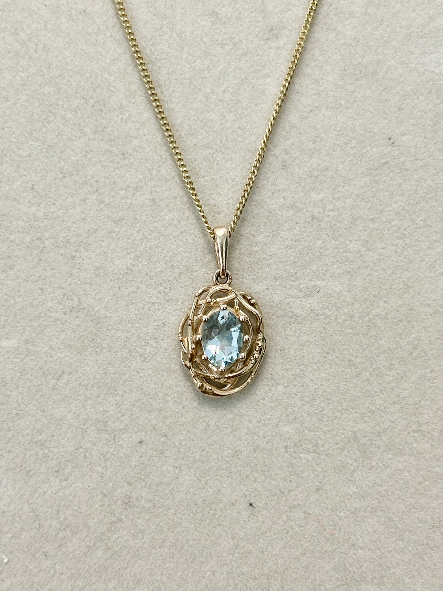 Oval natural aquamarine Nest pendant in 14K yellow gold